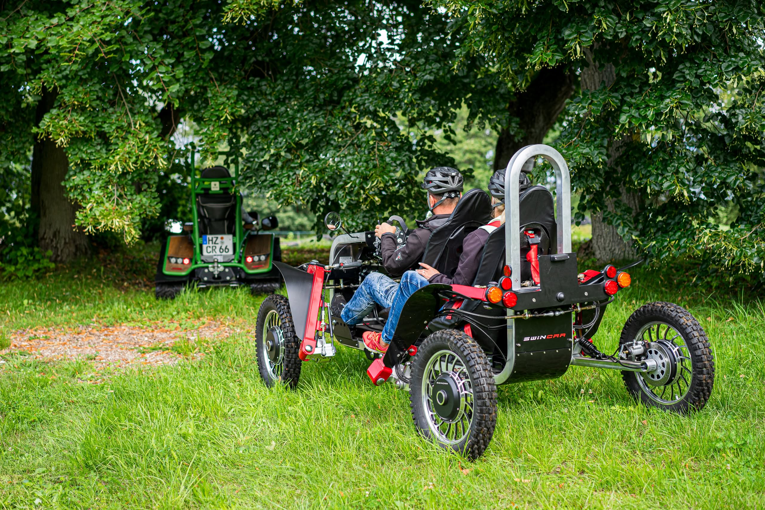 Zwei Personen in einem geländegängigen Fahrzeug im Park