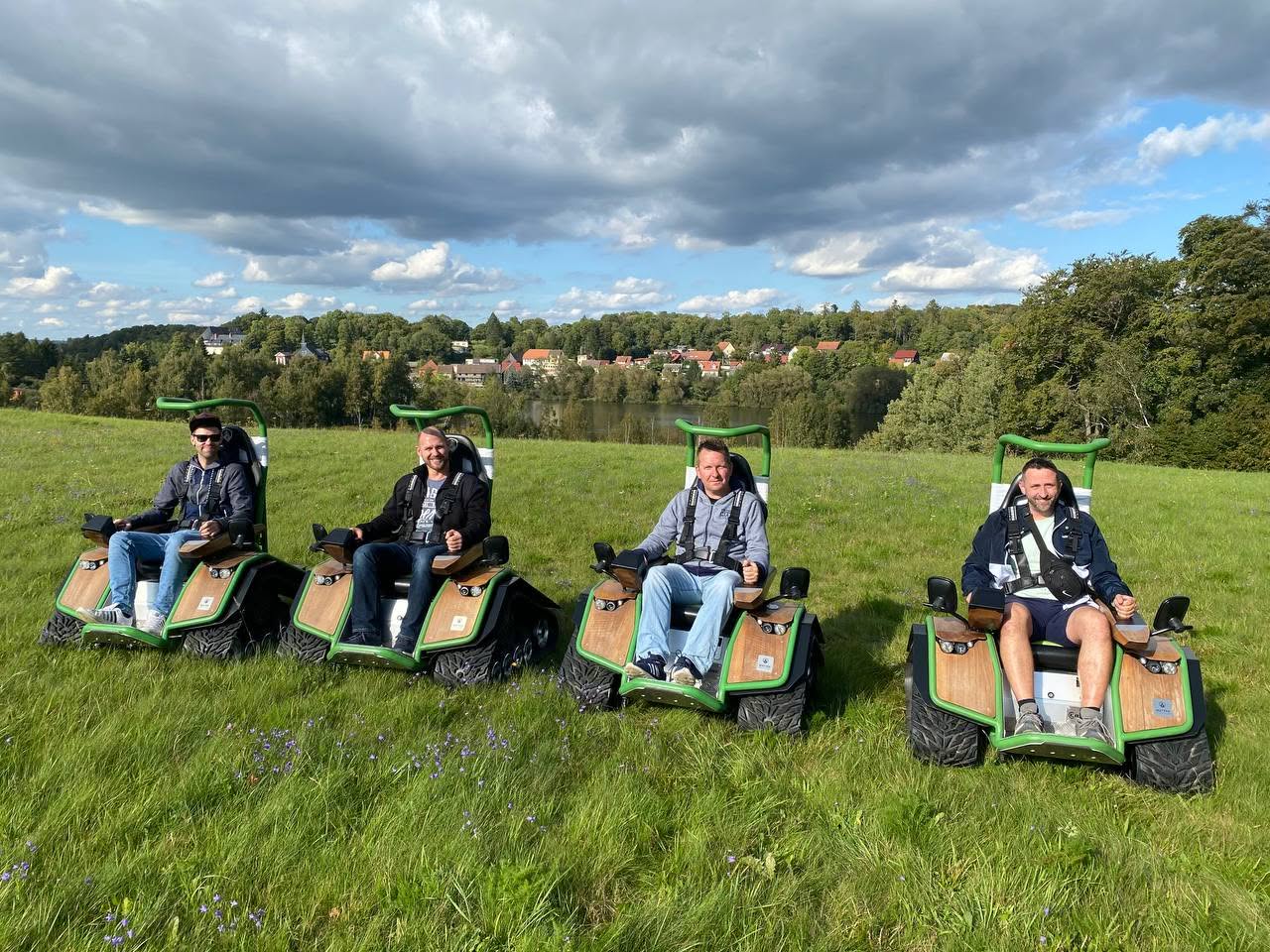Vier Männer auf elektrischen Geländefahrzeugen im Freien.